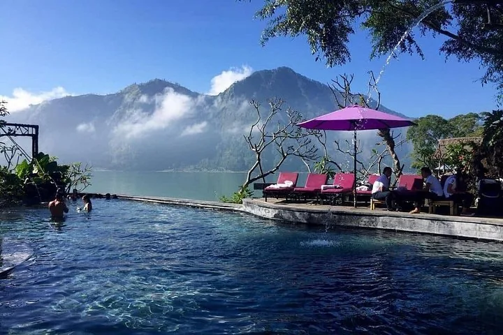 Menschen entspannen in heißen Quellen mit malerischem Blick auf See und Berge
