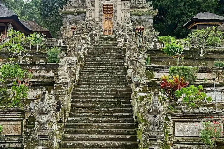 Steinstufen, die zu einem kunstvollen balinesischen Tempel mit Statuen hinaufführen